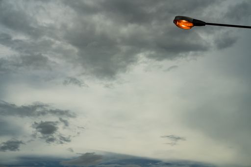 A lighted street lamp on a grey sky background