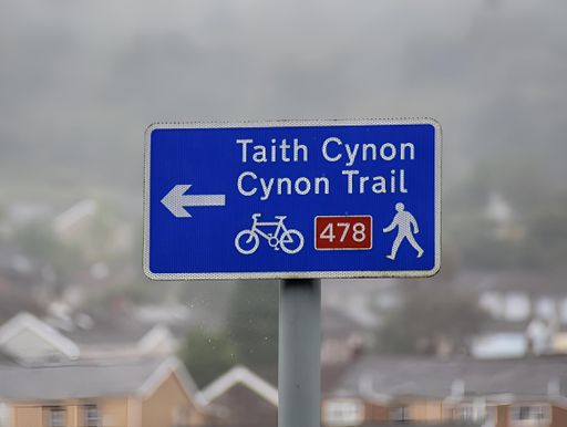 A signpost for the Cynon Trail in Mountain Ash, set against a natural backdrop