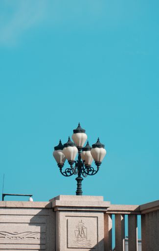 A street lamp on a building against the blue clear sky
