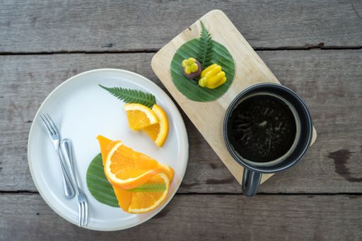 A top view of an orange pie and a coffee mug on a wooden table