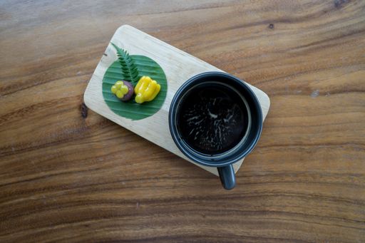 A closeup of a cup of coffee on the wooden table. Top view.
