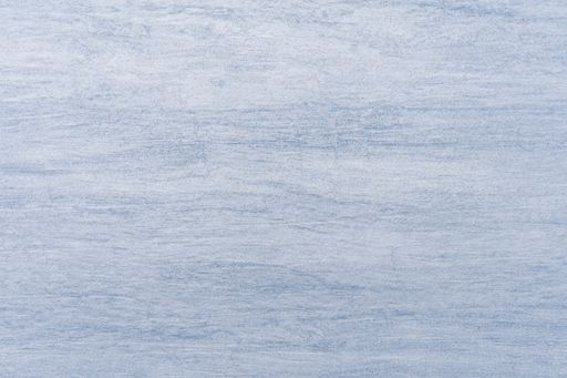 A pale blue wall texture with a streaky pattern - Background of a plain blue wall