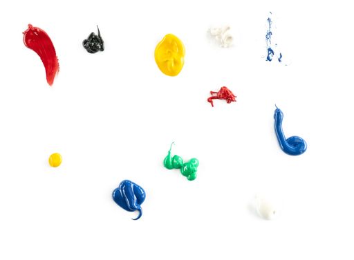 A top view of a small amount of various colorful paint on the white surface