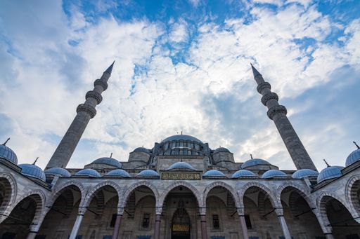 A low angle view of the Suleymaniye Mosque under a cloudy sky and sunlight in Istanbul in Turkey