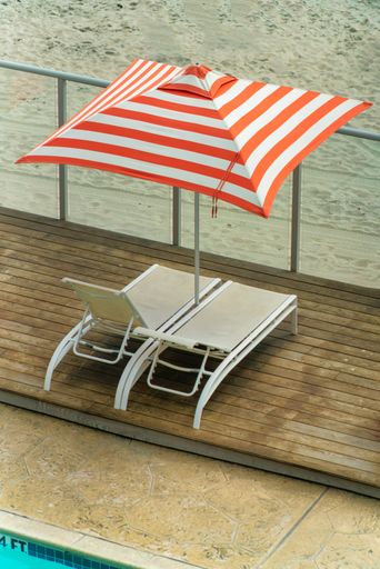 Two sun loungers under a striped umbrella at the beach