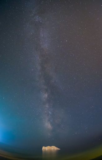 A vertical shot of a milky way visible over the small island opposite Skala Eresos