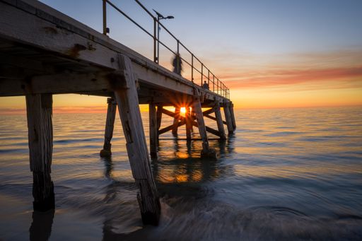 A pier over the calm sea during sunset