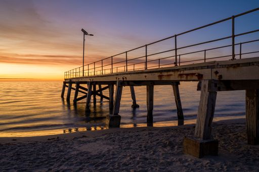 A pier over the calm sea during sunset