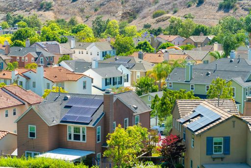 A beautiful shot of neat modern buildings in a rural town with solar panels on their roofs in the summer