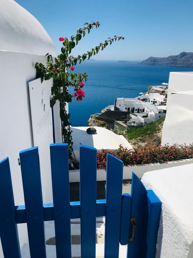 A vertical view of a coastal white house in the island of Santorini on a clear sunny day in Greece