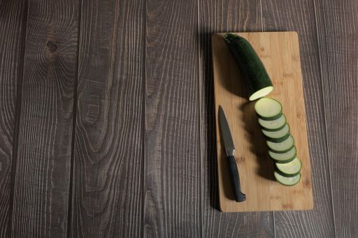 A сloseup of sliced cucumber on a wooden board.