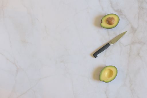 A сloseup of sliced avocado on a marble table. Top view.