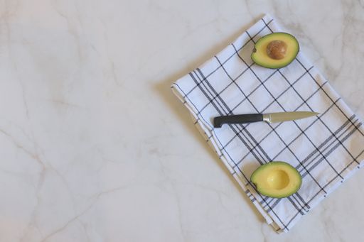 A сloseup of sliced avocado on a marble table. Top view.