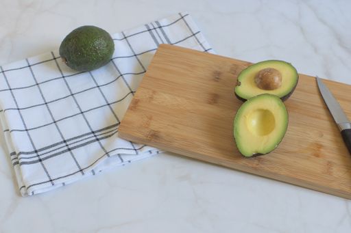 A сloseup of sliced avocado on a wooden board.