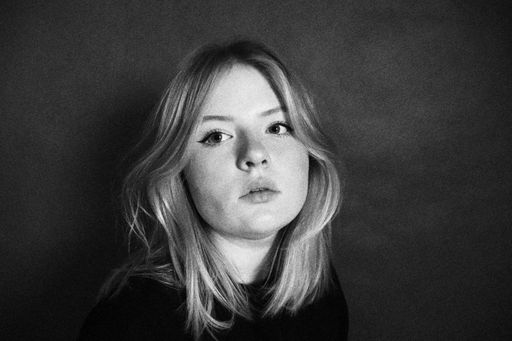 A closeup shot in black and white of a Caucasian attractive, blond woman posing in a sexy way