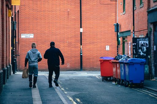 A back view of two males walking in a Manchester alleyway in the UK