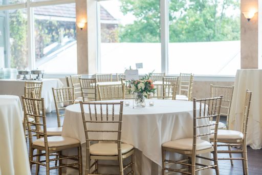 A shot of the table setting of the bright and decorated dining area of the wedding hall