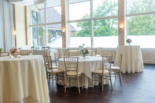 The hall of a restaurant with white tables and transparent windows