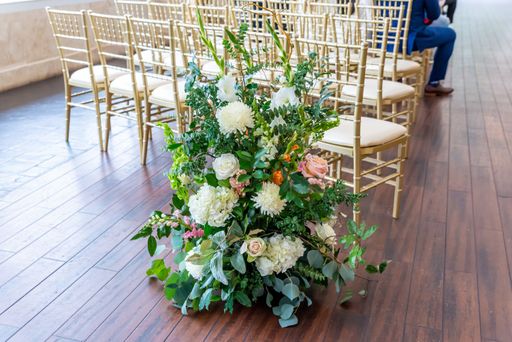 A high angle shot of a beautiful bouquet of white and pink flowers on the wooden floor at a wedding