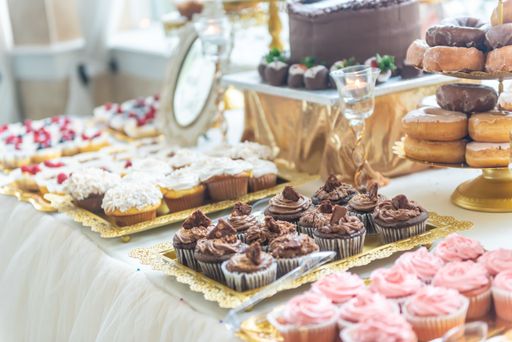 A closeup high angle shot of cupcakes, donuts, and muffins on a beautifully decorated table