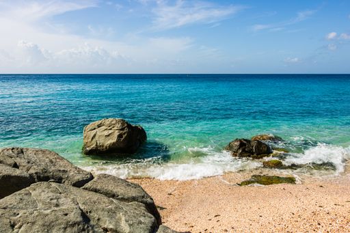A beautiful shot of the sand and clear blue water of St. Barths Island, Caribbean sea