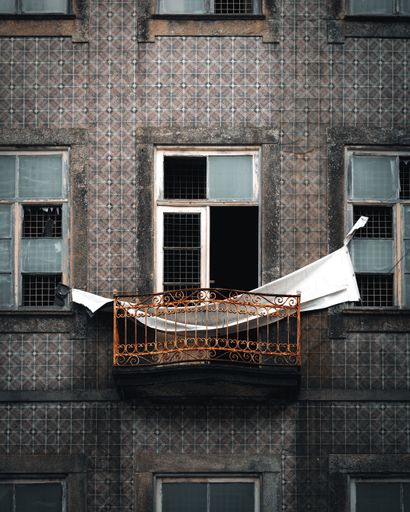 A vertical shot of a balcony of an old building in Porto, Portugal