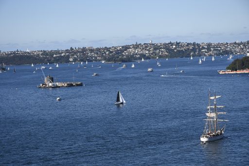 An aerial view of boats and ships on the blue water under a clear sky in Sydney, Australia