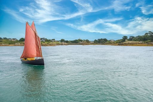 Brehat island in Brittany, a traditional sailing boat, view of the the coastline