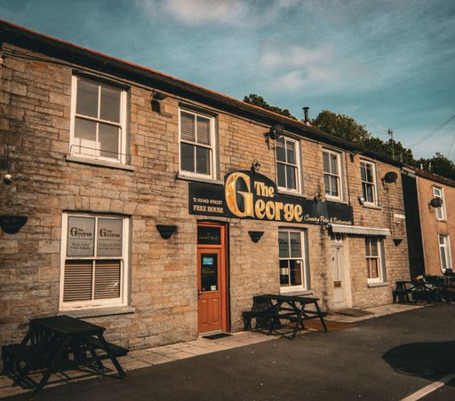The facade of George Pub in Mountain Ash, South Wales under blue cloudy sky