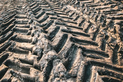 A closeup shot of tractor tire tracks on a muddy ground