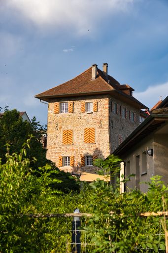 A scenic view of an old brick house in Sempach, Switzerland under a blue sky