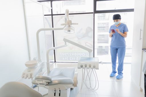 The dentist at her office checking the phone.
