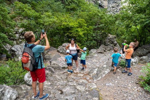 The group of people standing on a stone footpath on the mountain in the National Park  Paklenica