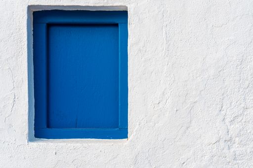 Old blue wooden door in a white wall
