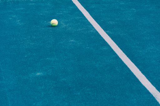 paddle tennis ball on a blue paddle tennis court, concept of racket sports