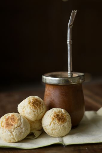 A vertical shot of Yerba mate and chipa cheese bread on the table