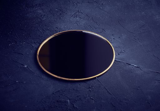 A closeup shot of a mirror on a blue background