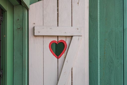 A closeup shot of a wooden door with the number seven and heart on green wooden background