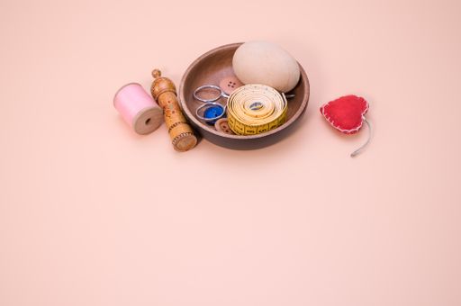 A set of sewing tools isolated on a peach background with free space for text