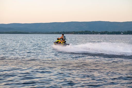 A person riding a jet ski on the water during a vibrant sunset.