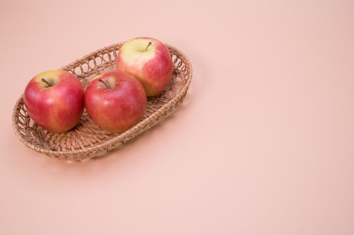 A tray of red apples isolated on a pink background with free space for text