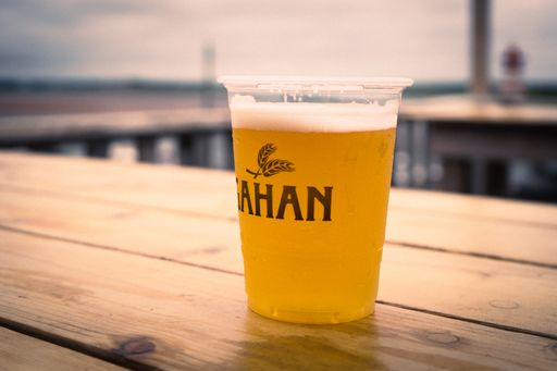 A closeup shot of a beer in a plastic cup on the table