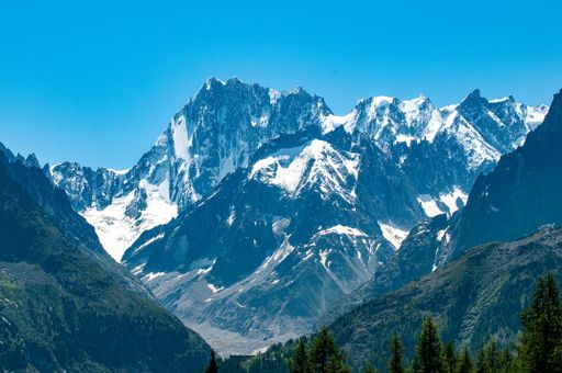 View across the Chamonix valley to the mountains near Mont Blanc, on a bright blue sky summer