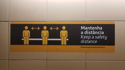 A rectangular sticker on the floor in Portuguese meaning "Keep a safety distance"; new normal during the covid pandemic
