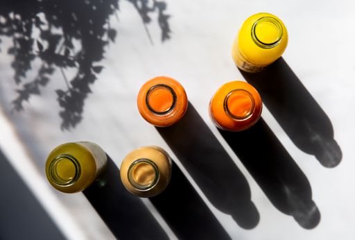 A top view of fresh fruit juice bottles on a white background