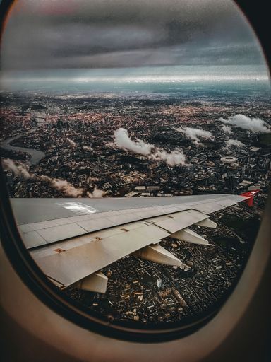 A vertical view of London City from an airplane window on a cloudy day