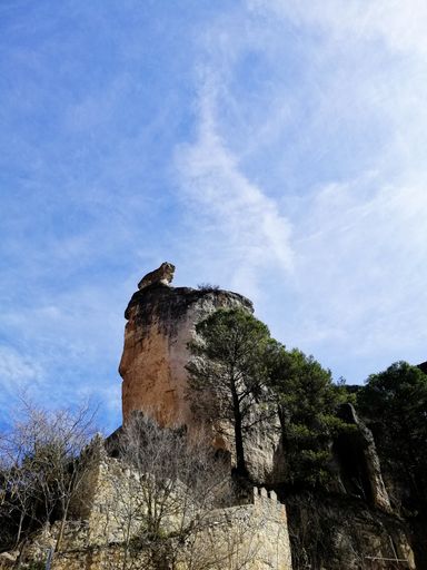 A beautiful shot of old buildings on the cliff with the blue sky in the background in Cuenca, Spain