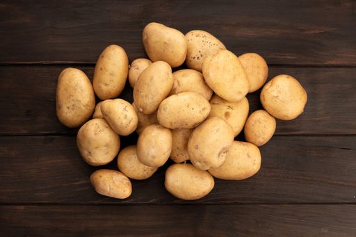 Group of New potatoes on wooden table. Top view