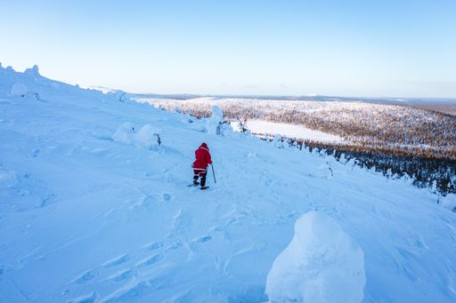 Aerial drone view of Santa looking towards fells and arctic wilderness, windy winter day, in Lapland, Finland