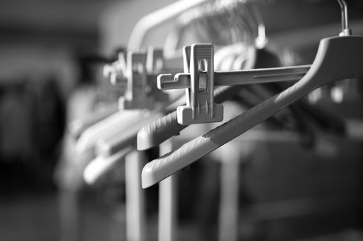 Photograph of empty clothes hangers at the backstage of a fashion show